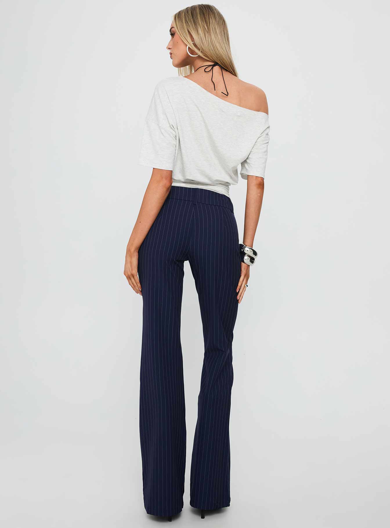 back view of model wearing Princess Polly Kinkirk Flared Pants Navy Pinstripe Low Rise Pants 