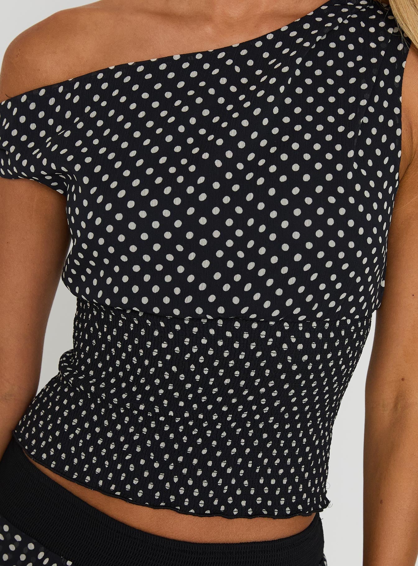 back view of model wearing Princess Polly Ready To Party Off Shoulder Top Black Polka Sleeveless Asymmetric Neckline 