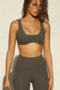 Front view of model posing in the stretchy and sculpting sueded carob contour bra with a deep scoop neckline and curved hem