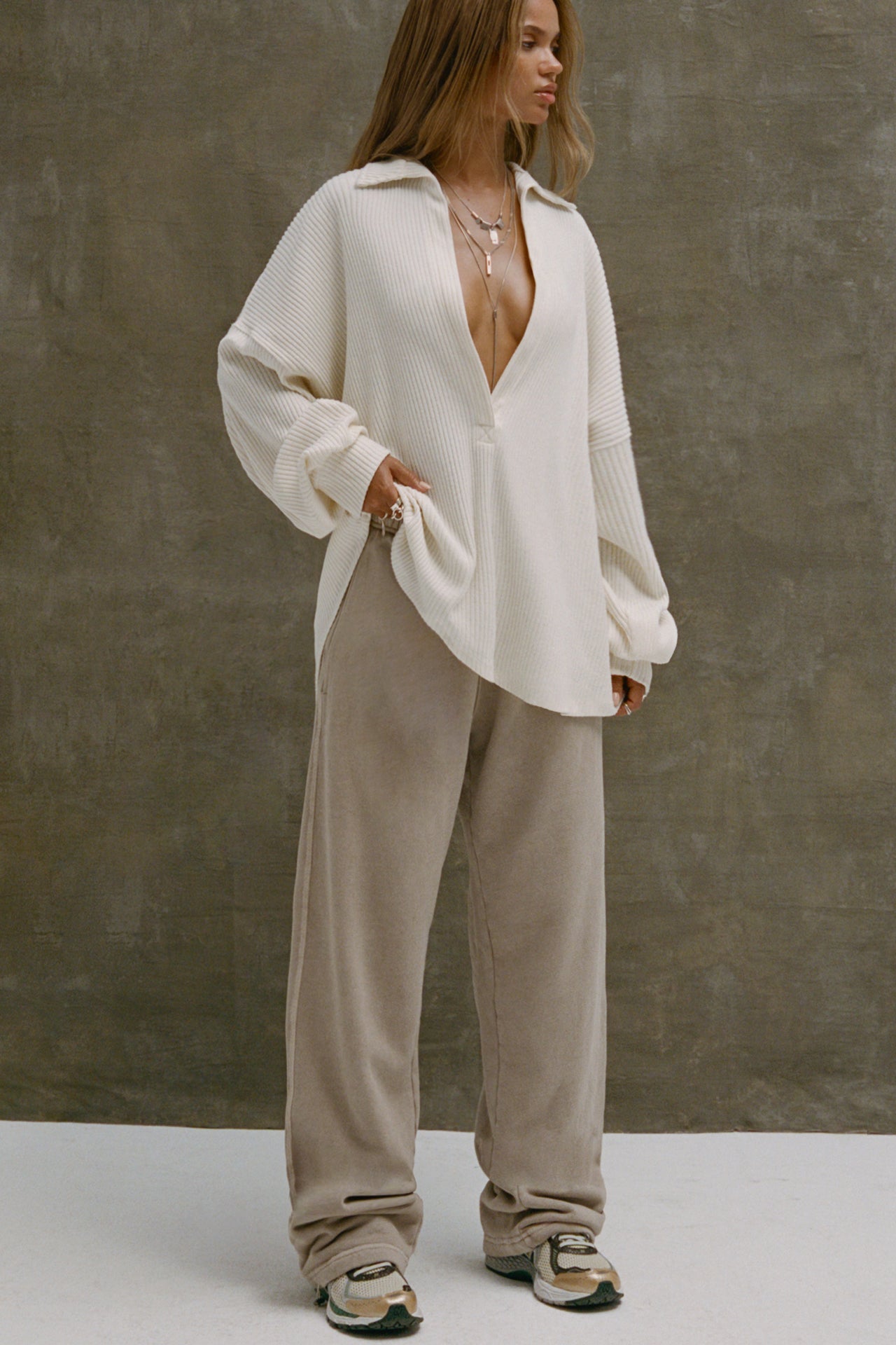 Full body front view of model posing in the oversized natural luxe knit Deep V Pullover with a plunging collared neckline and dropped shoulders