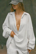 Front view of model posing in the oversized pearl grey luxe knit Deep V Pullover with a plunging collared neckline and dropped shoulders
