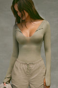 Front view of model posing in the fitted sage modal Notched V Neck Long Sleeve top with a deep notched V-neckline, extra long sleeves and small side slits at the hem