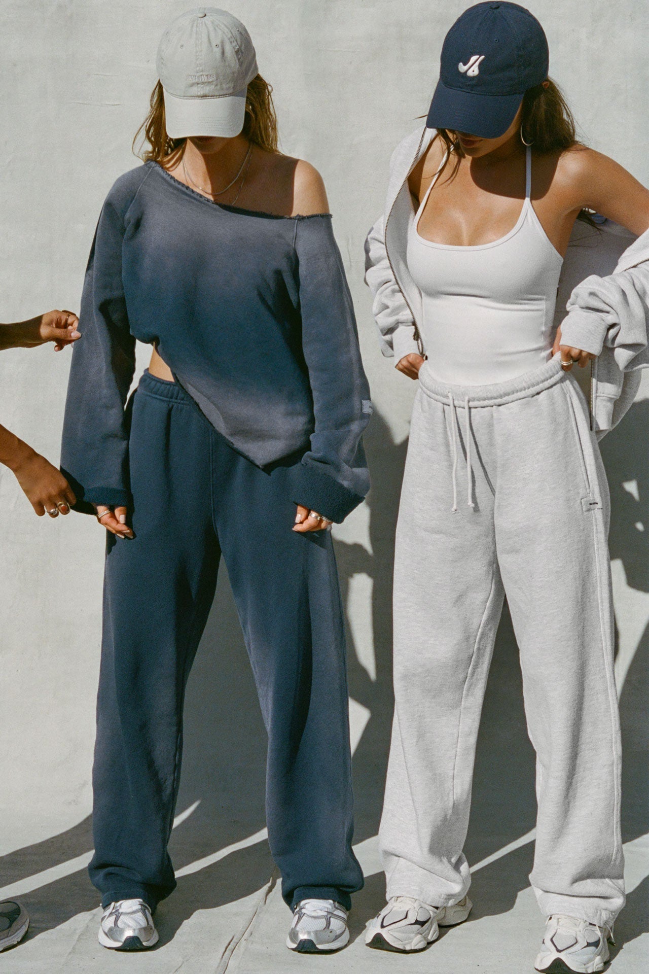 Two modes posing in a heritage washed navy french terry sweat set and a white sueded halter top and pearl french terry bottom set. 