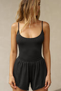 Front view of model posing in the fitted black modal Scoop Neck Cami with thin adjustable straps, scoop neckline and scoop back