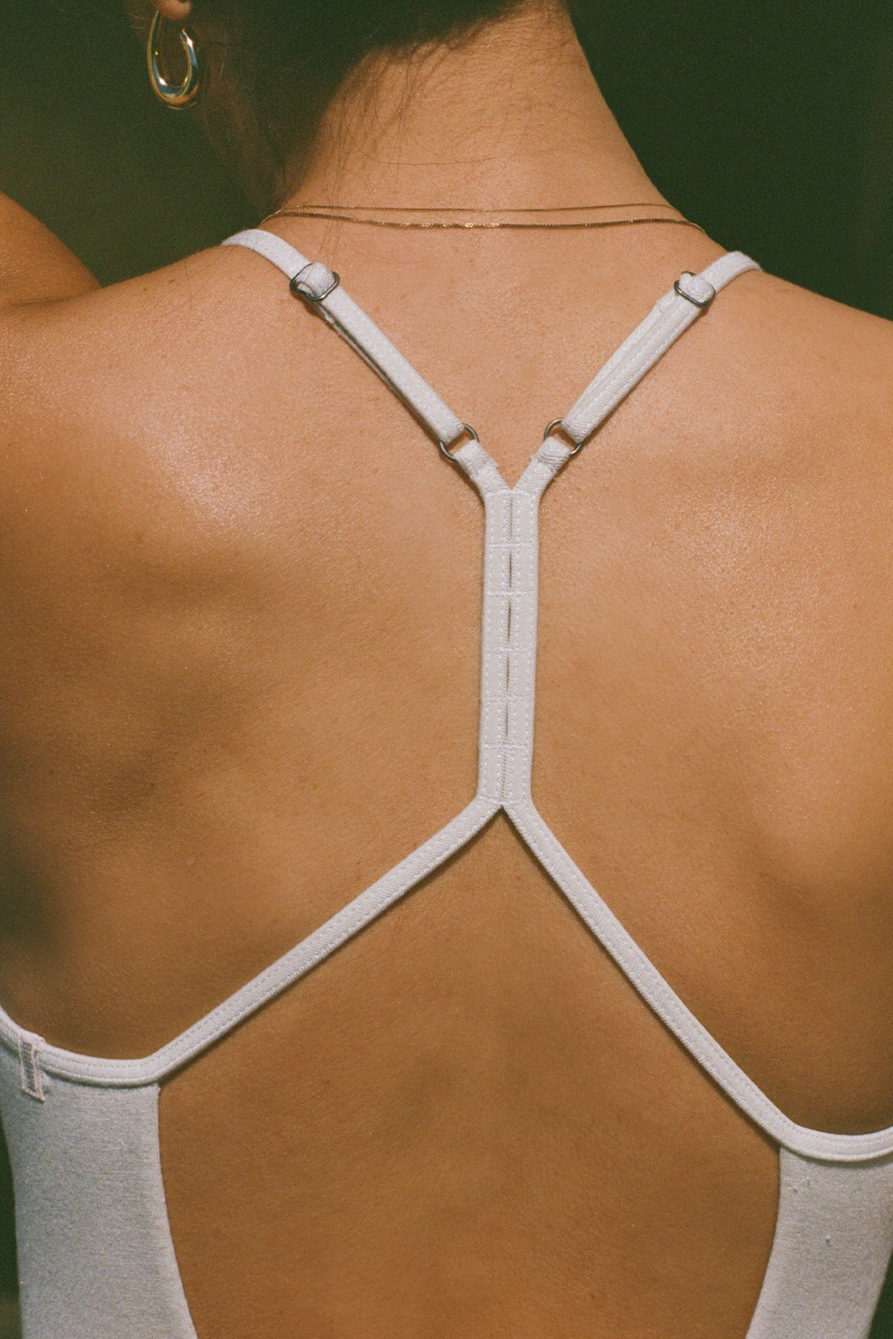 Close up detail back view of model posing in the fitted chalk modal Open T-Back Cami with an open t-back design
