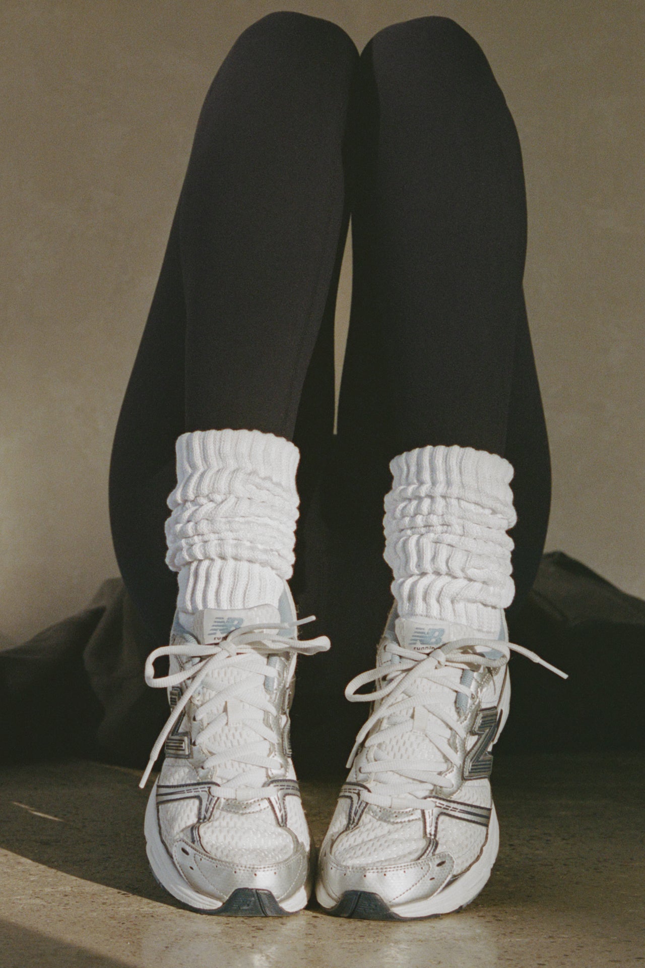 Front view of model posing in the slouchy classic white Scrunch Sock with extra long ribbed cuffs
